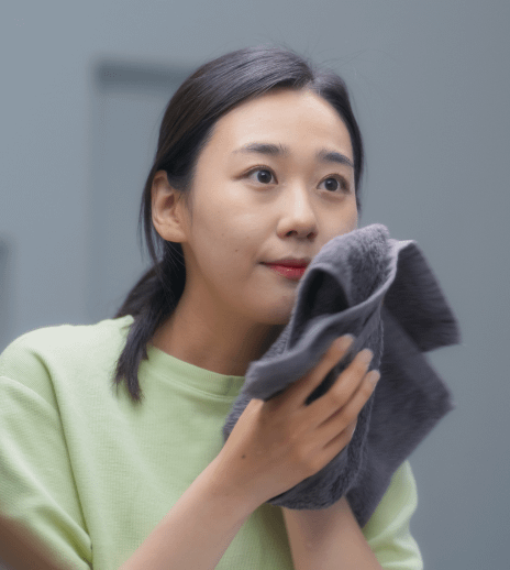 girl is washing her face using a cloth