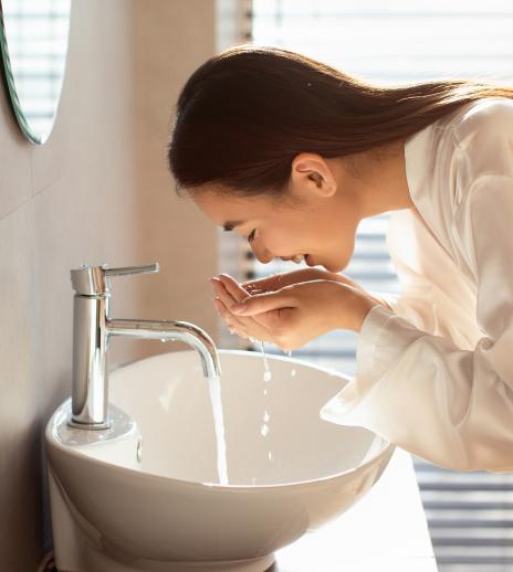 woman washing her face with soap
