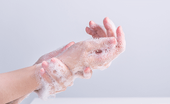 hands covered in bubbles while washing in soap