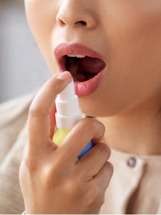 Woman with her mouth open is about to use BETADINE Throat Spray
