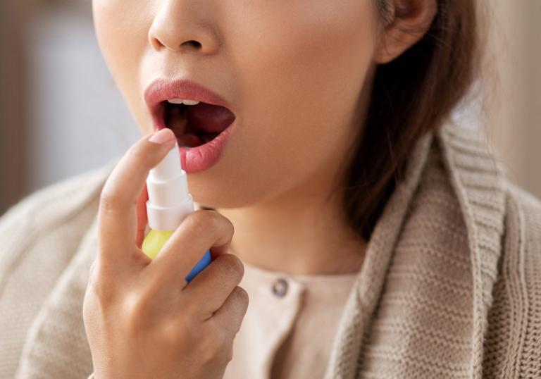 Woman using BETADINE Throat Spray